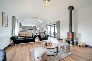Ein geräumiges Wohnzimmer mit Kamin, zwei Sofas, einem Couchtisch und einem Essbereich.