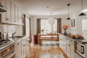Une cuisine moderne avec des meubles en bois, un îlot central et des luminaires suspendus.