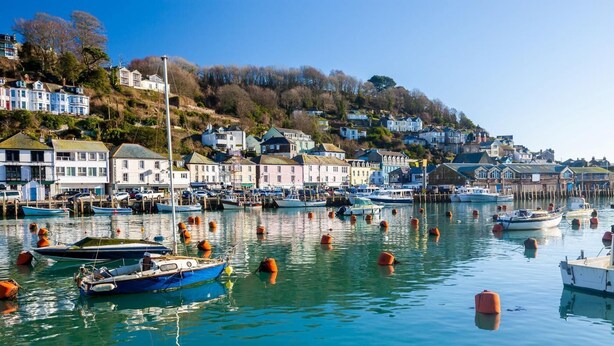 Un puerto con barcos y casas en una colina.