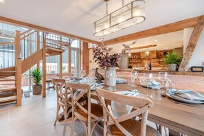 A dining area with a wooden table, chairs, and a chandelier. - 4 Bed in Moccas (oc-r33126) (Moccas)
