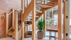 A wooden staircase with glass railings, wicker baskets, and a potted plant in a modern interior. - 4 Bed in Moccas (oc-r33126) (Moccas)