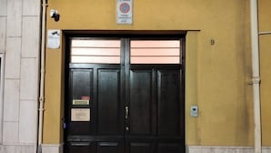A closed double door with a security camera above and a no parking sign above it. - Swabian castle suite  (Brindisi)