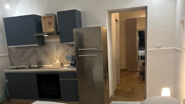 A compact hotel room with a bed, a kitchenette, and a bathroom visible through an open door. - Swabian castle suite  (Brindisi)