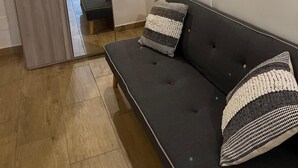 A modern living room with a sofa, a flat-screen TV mounted on the wall, and a large mirror reflecting the room. - Swabian castle suite  (Brindisi)