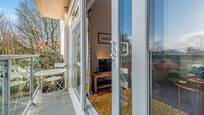 A balcony with a table and chairs, a sofa, and a TV. - 2 Bed in Tenby (oc-t33804) (Tenby)