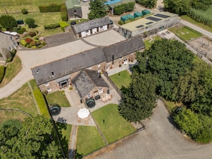 An aerial view of a property with a large building, a smaller adjacent structure, and a well-maintained lawn. - 4 Bed in Shebbear (oc-w33730) (Shebbear)