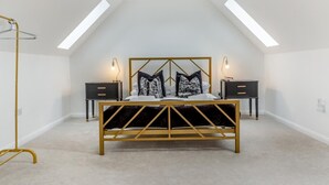 Ein Schlafzimmer mit einem Bett, zwei Nachttischen, einer Stehlampe und einer Deckenleuchte.