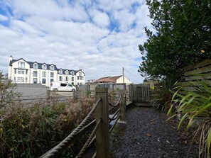 A gated entrance to a residential area with a white van parked in front. - 2 Bed in Benllech (oc-t34071) (Benllech)