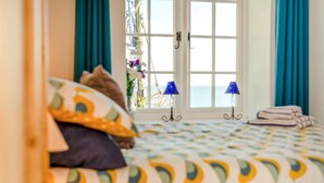 A bedroom with a bed, a view of the outdoors, and a window with curtains. - 3 Bed in Polperro (oc-h34100) (Polperro)