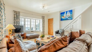 A living room with a sofa, a television, a lamp, and a painting of a sailboat. - 3 Bed in Polperro (oc-h34100) (Polperro)