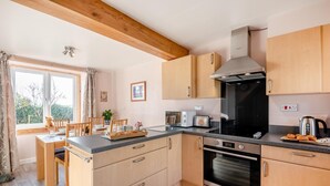 Eine kleine Küche mit Holzausstattung, einem Einbauofen und einem Toaster.