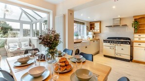 Une cuisine moderne avec un coin repas, de grandes fenêtres et un espace salon confortable.