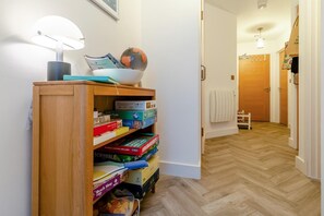 A hallway with a wooden bookshelf filled with board games and a globe. - 2 Bed in Fowey (oc-h33067) (Fowey)