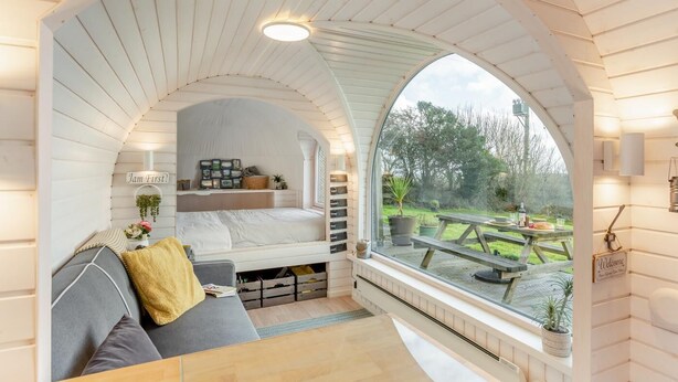 A cozy room with a built-in bed, a bench, and a window overlooking a garden. - 1 Bed in Widegates (oc-j34234) (Deviock)