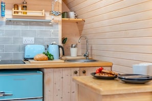 A compact kitchen with a toaster, kettle, and a sink.