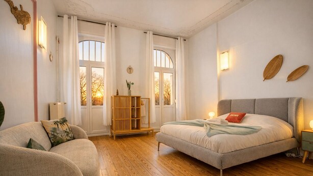 Una camera da letto con un letto, un divano, un armadio in legno e una finestra con tende.