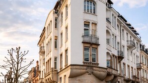 Un edificio storico con un design architettonico unico, caratterizzato da una facciata curva e numerosi balconi.