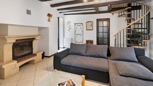 Una sala de estar con chimenea, una escalera curva y un sofá.