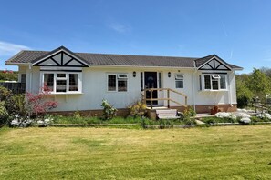 A two-story house with a front porch, a small garden, and a clear blue sky. - 2 Bed in Harbury (oc-b34221) (Harbury)