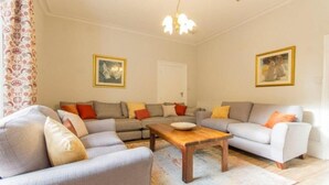 Ein Wohnzimmer mit zwei Sofas, einem Couchtisch und einer Deckenleuchte.