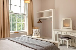 A bedroom with a bed, a bedside table, a dresser, a mirror, and a window with curtains. - 7 Bed in Matlock Bath (oc-n34368) (Matlock Bath)