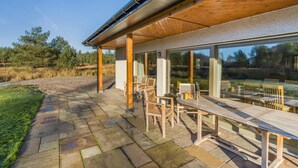 Eine moderne Außenpatio mit Steinböden und Holzmöbeln.