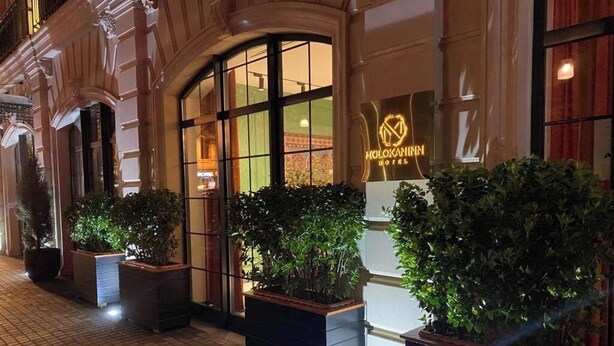 The exterior of the Molokaniinn Hotel with its entrance, large windows, and potted plants. - Molokan Inn Hotel (Baku)