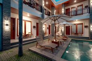 A multi-level hotel with a pool area, outdoor seating, and a staircase. - Casa Nika Suites Seminyak (Denpasar)
