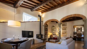 Ein gemütliches Wohnzimmer mit Kamin, einem Essbereich mit Tisch für vier Personen und einer bequemen Couch.