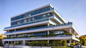 Un edificio de varios pisos con techo plano, ventanas amplias y balcones.