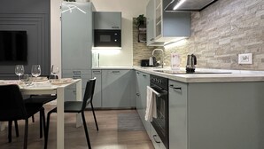 A modern kitchen with grey cabinets, a built-in microwave, a stove, and a sink. - [Venice-Mestre]Design Apartment Bros#1 (Venezia)