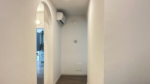 A hallway with a wooden floor, white walls, and an air conditioning unit on the wall. - [Venice-Mestre]Design Apartment Bros#1 (Venezia)