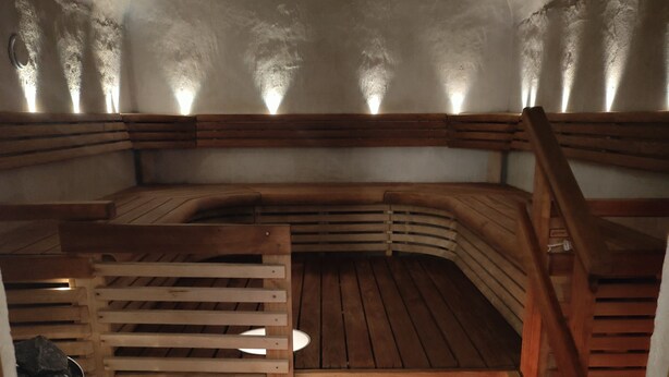 A sauna with wooden benches and a sloped ceiling.