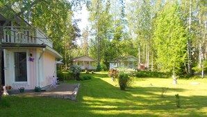A residential area with two houses, a well-maintained lawn, and a small garden.
