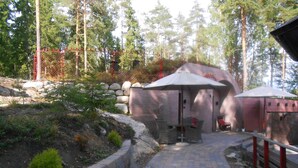 A pathway leading to a building with outdoor seating and umbrellas.