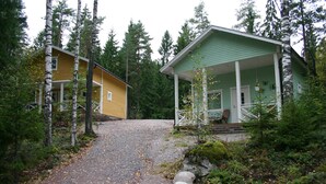 Un lodge a due piani con veranda e vialetto sterrato che conduce all'ingresso.