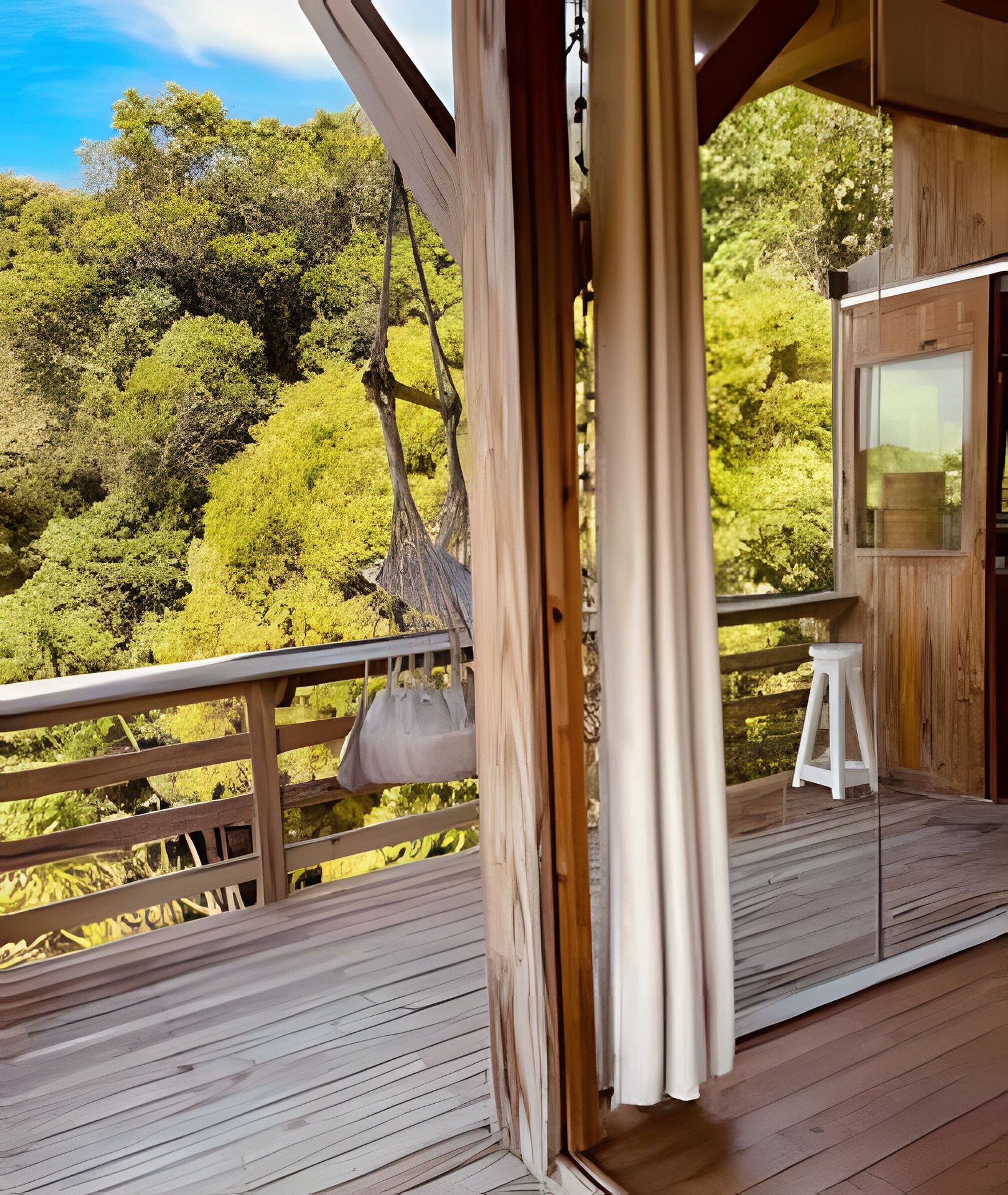 A wooden deck with a hanging bag, a small stool, and a view of dense green trees.