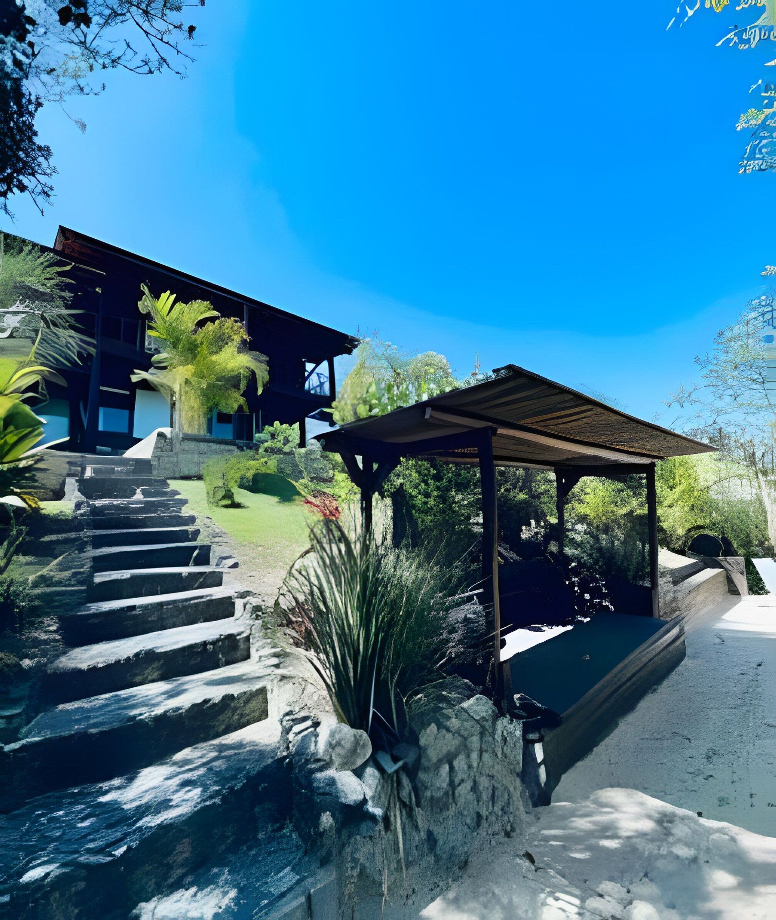 A modern building with a stone staircase leading to a covered outdoor area.