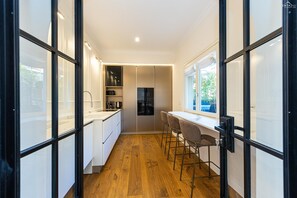A modern kitchen with white cabinets, a wooden floor, and a window overlooking a parking area. - Trevi Terrace apartment - Luxurious apartment near the Trevi Fountain, in Piazza Scanderbeg (Rome)