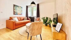 A modern living room with a sofa, a chair, a small table, and a plant.
