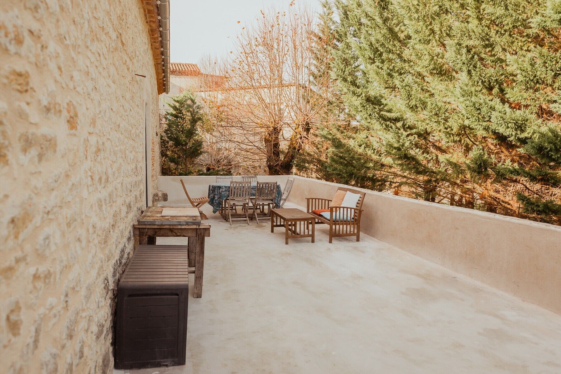 A rooftop patio with a table, chairs, and a sofa.
