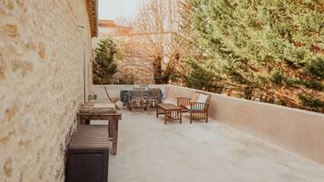 A rooftop patio with a table, chairs, and a sofa.