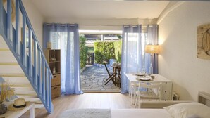 A bedroom with a bed, a desk, and a staircase. - Bright studio close to the beach in Roquebrune (Roquebrune-sur-Argens)