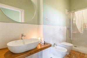 A bathroom with a large oval sink, a toilet, and a shower. - Appartamento delle Pietre (Cortona)