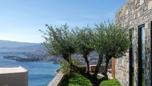 Un bâtiment moderne aux murs en pierre, offrant une vue sur la mer.