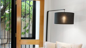 Un salon moderne avec un canapé blanc, un lampadaire noir et une petite table ronde sur laquelle est posé un bol décoratif.