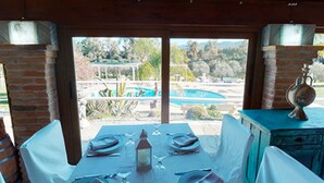 A dining area with a table set for four, overlooking a pool and greenery. - Room 'Mirto' with Mountain View, Wi-Fi and Air Conditioning (Uta)