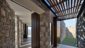 A modern interior with stone walls, a wooden slatted ceiling, and a view of a stone courtyard. - Villa Narethea, Divine Sea Views, Private Pool, Furnished Terrace, Crete (Crete)