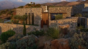 A stone building with a wooden door, surrounded by vegetation and hills in the background. - Villa Narethea, Divine Sea Views, Private Pool, Furnished Terrace, Crete (Crete)