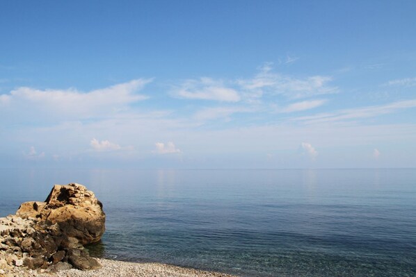 A rocky coastline with clear water and a calm sea.